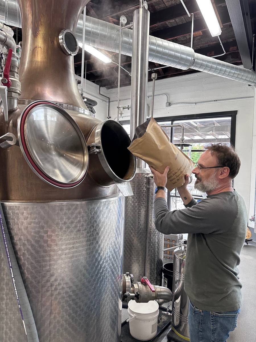 Our distiller loading coffee into the still